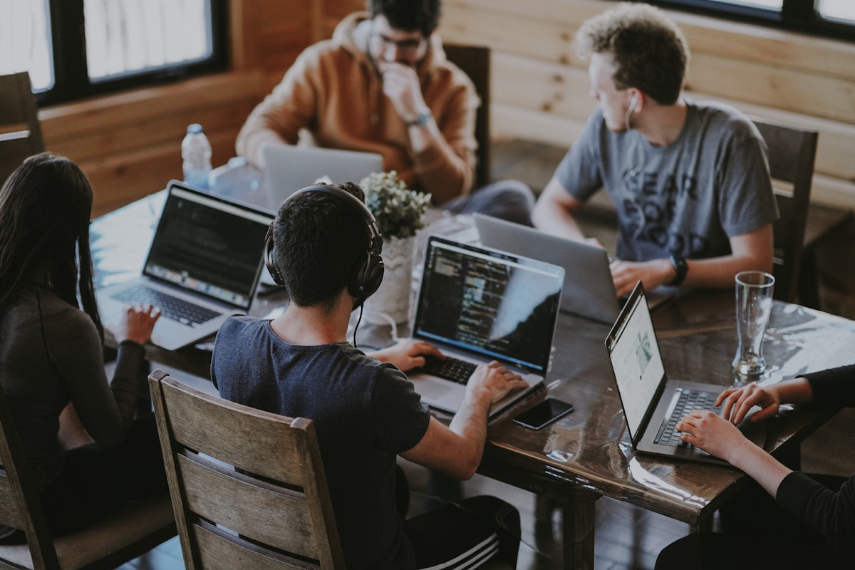 Team members collaborating around a laptop